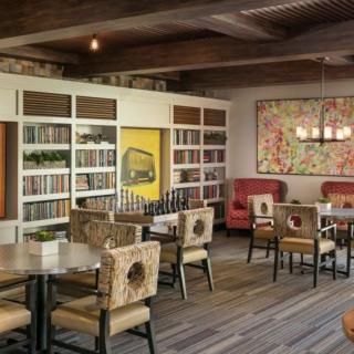 A cozy restaurant interior featuring a bookshelf and decorative art.
