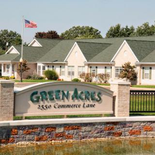 Entrance to Green Acres community featuring residential buildings and an American flag.