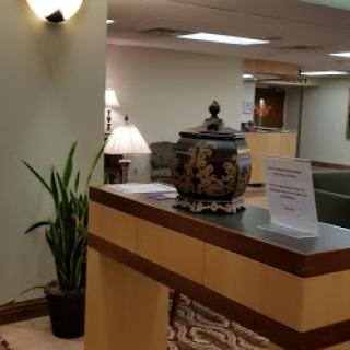 A welcoming reception area featuring a decorative pot and indoor plant.