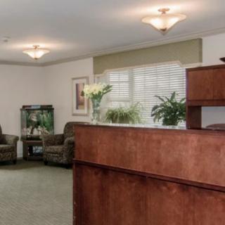 A reception area with comfortable seating, an aquarium, and indoor plants.