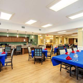 A spacious dining area with blue tablecloths and neatly arranged seating.