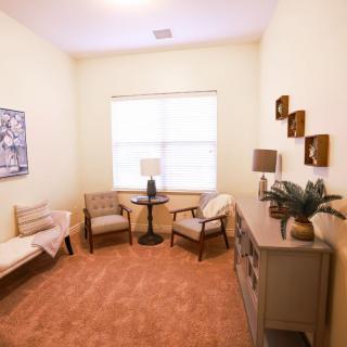 A cozy living room with comfortable seating, a side table, and decorative elements.