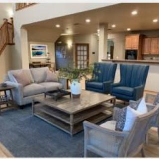 A beautifully designed living room with comfortable seating and a view of the kitchen.