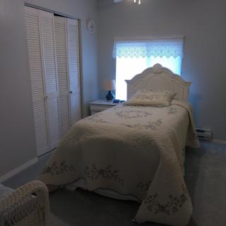 A cozy bedroom with a single bed and soft lighting.