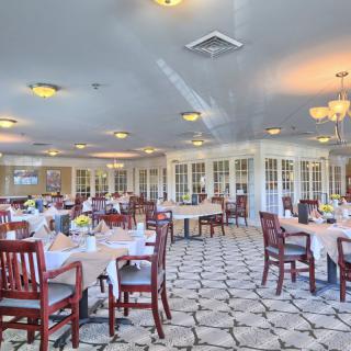 An elegant dining room interior with neatly arranged tables and chairs.