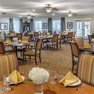 An elegant dining room set up with tables and chairs, ready for guests.