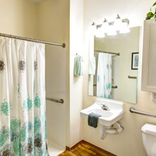 A bright and clean bathroom with a shower curtain, sink, and mirror.
