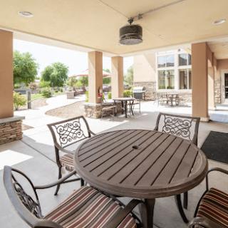 A cozy outdoor patio area with a round table and chairs, perfect for gatherings and enjoying the sunshine.
