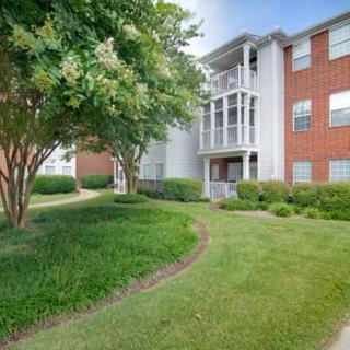 A well-maintained apartment building with a brick facade and lush landscaping.