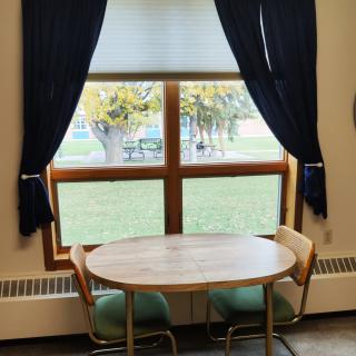 A cozy table setup by a window with dark curtains.