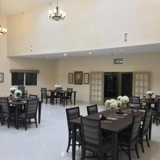A spacious dining area featuring elegant furniture and decorative flowers.