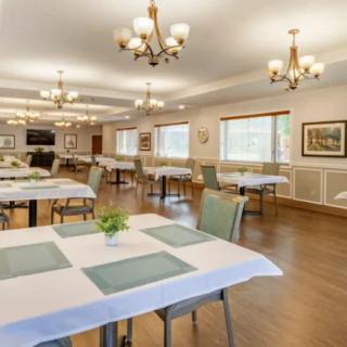 A spacious and elegant dining room with neatly arranged tables and chandeliers.