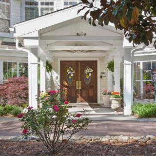 A charming house entrance with a garden and flowers.