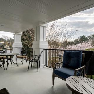 A peaceful porch with multiple seating areas and a scenic view.