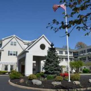 A residential building with a driveway and American flag in front.