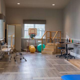 A physical therapy room equipped with various exercise and rehabilitation equipment.