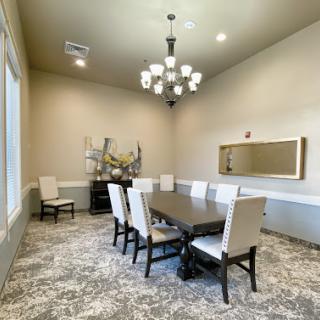 A spacious dining room featuring a large table, elegant chairs, and a stylish chandelier.