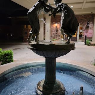 A beautifully illuminated fountain featuring two figures at night.