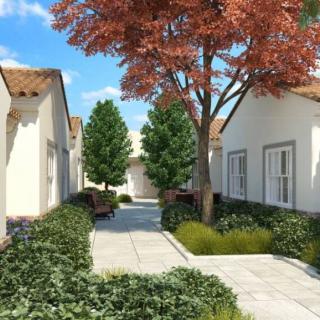 A picturesque garden pathway lined with trees and quaint houses.