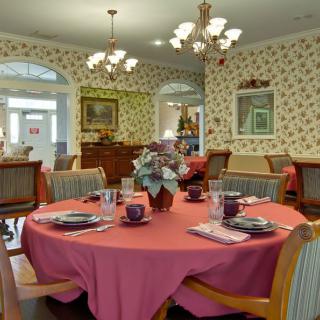 An elegantly set dining room with floral decorations and chandeliers.
