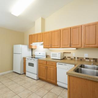 A spacious kitchen with wooden cabinets and modern appliances.