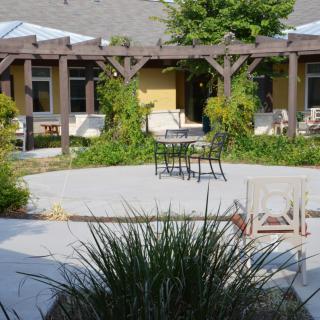 Cozy outdoor patio area with seating and lush greenery.