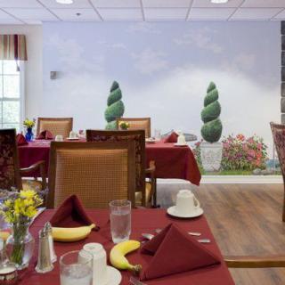 A cozy dining room with neatly arranged tables and decorative wall elements.