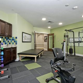 A well-equipped home gym with various exercise machines and weights, featuring a bright and inviting interior.