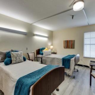 A modern bedroom with two neatly made beds, featuring stylish decor and soft lighting.