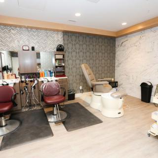 A cozy beauty salon featuring hair styling stations and a pedicure chair.