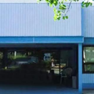 A blue building with large windows reflecting the surroundings.