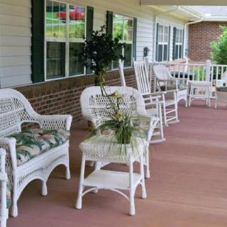 A cozy porch with wicker furniture and rocking chairs.