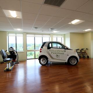 An innovative office space featuring a smart car parked indoors, showcasing modern design and ample natural light.