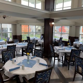 A spacious dining area with neatly arranged tables and chairs, featuring a well-lit interior design.
