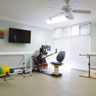 A well-equipped physical therapy room with exercise machines and rehabilitation tools.