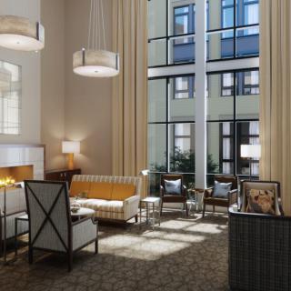 A modern hotel lobby with comfortable seating and large windows letting in natural light.