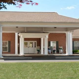 A building entrance with large columns and a covered porch.