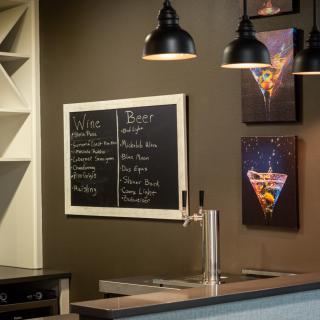 A cozy bar interior featuring a chalkboard menu with wine and beverage options.