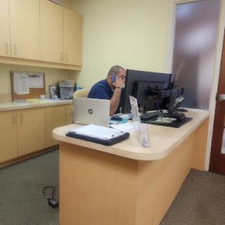 A person at an office desk working on a computer.