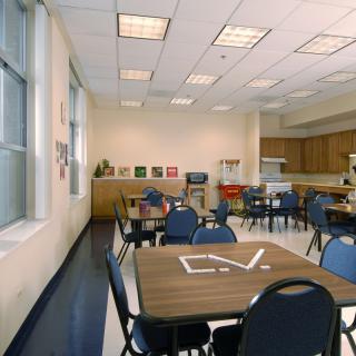 An empty classroom with tables and chairs arranged for learning.