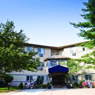 A residential apartment building with a main entrance and surrounding greenery.