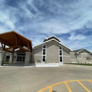 A modern architectural structure featuring a blend of concrete and wooden elements under a cloudy sky.
