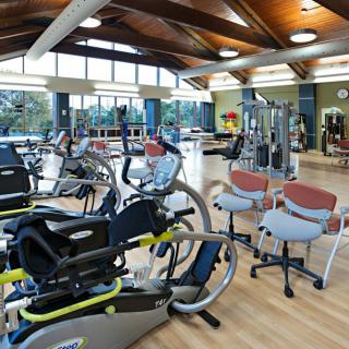 A spacious gym featuring various exercise machines and cardio equipment.