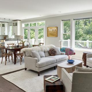 A modern living and dining area featuring elegant furniture and large windows that let in natural light.