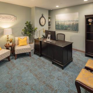 A cozy office setting with a desk, chairs, and decorative elements.
