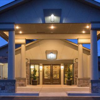 A well-lit building entrance with columns during the evening.
