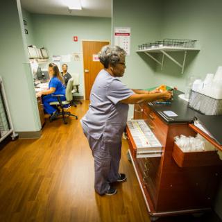 Healthcare staff working in a medical facility, focusing on patient care and administration tasks.