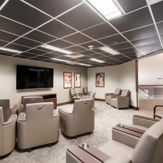 A modern lounge area with comfortable seating and a large TV.