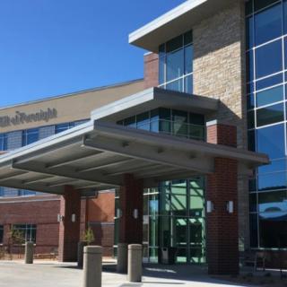 A modern hospital building with a glass entrance and architectural design.