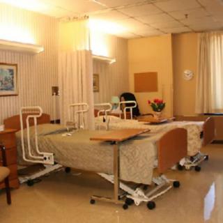A hospital room with patient beds and medical equipment.